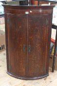 Georgian oak and mahogany bow front two door corner wall cabinet, 103cm high.