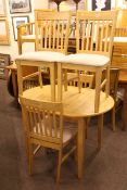 Lightwood extending dining table and four rail back dining chairs.