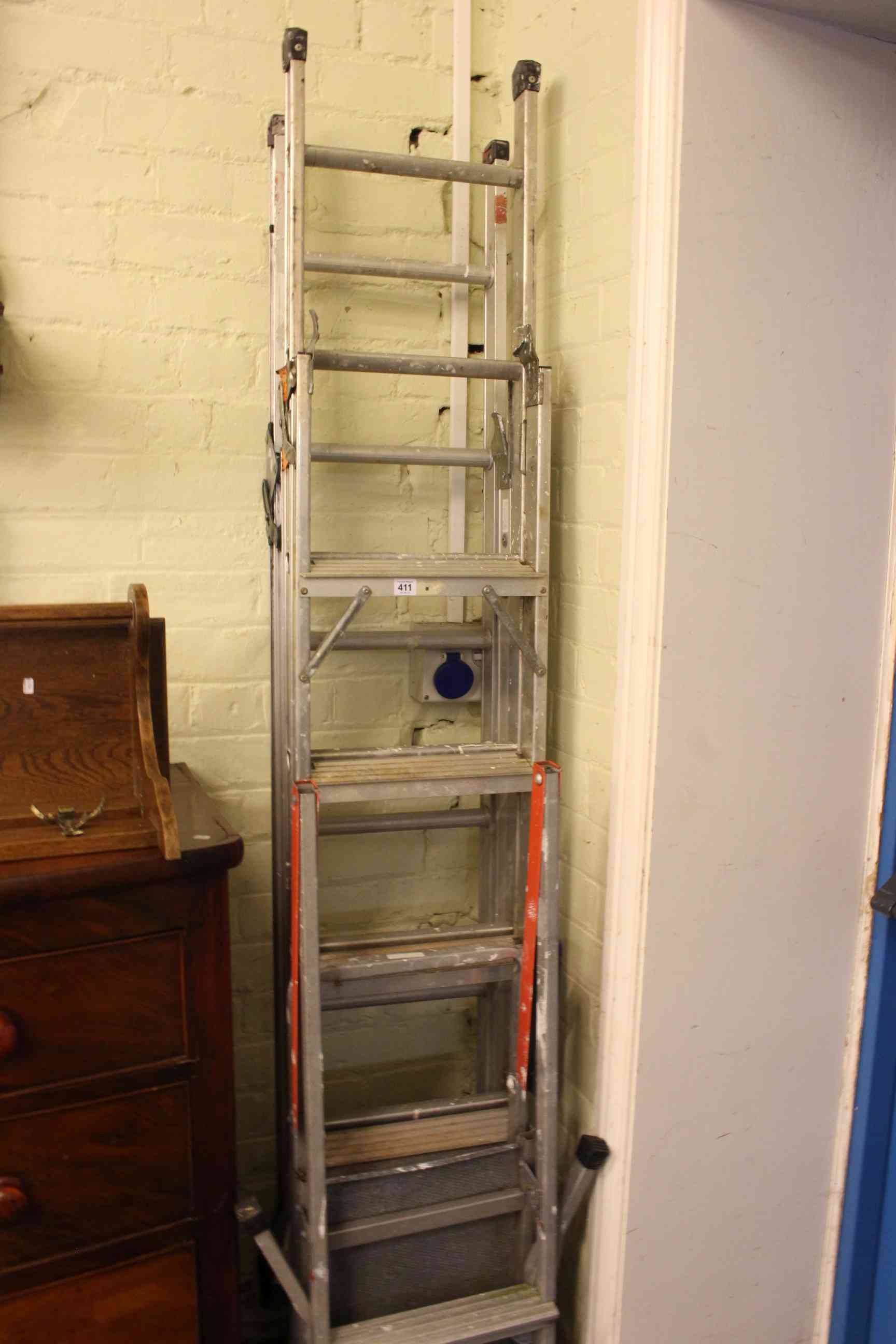 Three aluminium adjustable ladders.
