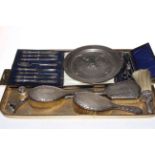 Three silver backed brushes, silver handled knives, button hooks, white metal dish, etc.