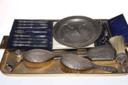 Three silver backed brushes, silver handled knives, button hooks, white metal dish, etc.