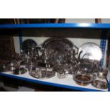 Collection of silver plated wares including ornate teapots, serving trays, tureen, candle holders,