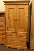 Pine combination wardrobe having two doors above two short and two long drawers.