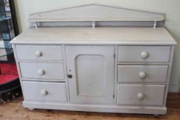 Victorian painted pine dresser having low arched back and central cupboard door flanked by two