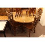 Oak finish circular breakfast table and four Windsor style chairs.