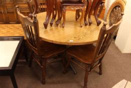 Oak finish circular breakfast table and four Windsor style chairs.