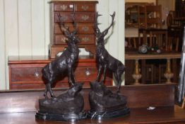 Pair of large impressive bronze models of stags on rocky outcrops raised on marble bases, 47cm high.