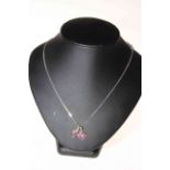 18 carat white gold, ruby and diamond pendant with 9 carat gold cross and 9 carat gold chain.