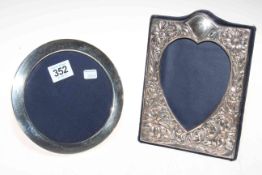 Two silver mounted easel photograph frames, circular and heart shaped.