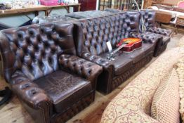 Brown deep buttoned leather three piece wing back Chesterfield suite.