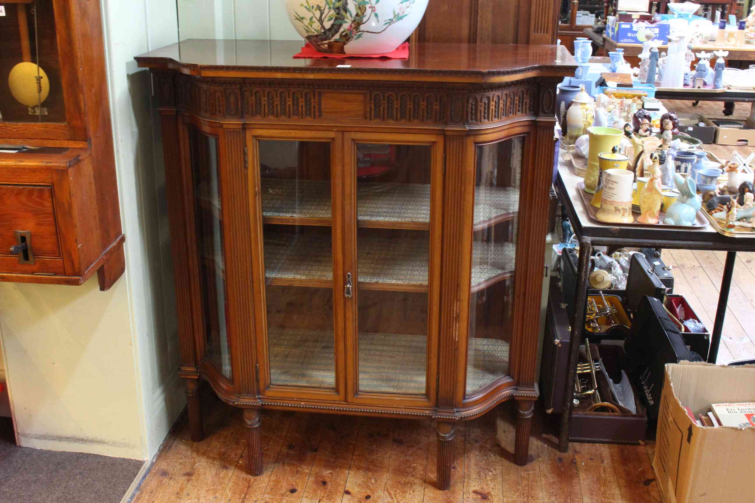 Late Victorian mahogany shaped front vitrine having carved Adams style frieze above pair central