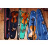 Three 3/4 size cased violins and bows.