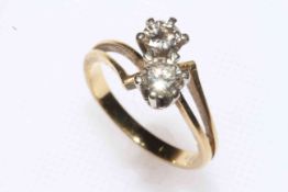 Two stone diamond ring set in unmarked yellow gold, the crossover setting with two stones,