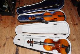 Two cased violins and bows.