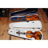 Two cased violins and bows.