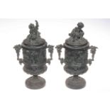 Pair of decorated cart iron cherub urns, 35cm high.