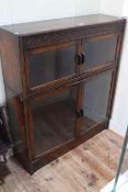 Early 20th Century carved oak glazed four door bookcase, 99cm high by 87cm wide by 25cm deep.