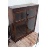 Early 20th Century carved oak glazed four door bookcase, 99cm high by 87cm wide by 25cm deep.