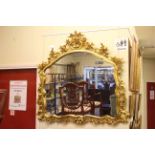 Ornate gilt framed overmantel mirror, 114cm by 120cm.