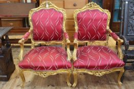 Pair gilt framed open armchairs with serpentine front seats.