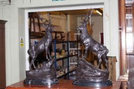 Pair of large impressive bronze models of stags on rocky outcrops raised on marble bases, 47cm high.