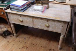 Early 20th Century limed oak two drawer haberdashery table having drop sides and turned legs,