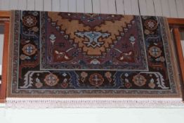 Wool rug with a fawn ground, 2.10 by 1.42.