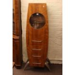 Contemporary rocket shaped cabinet having circular glazed panel door above three drawers,