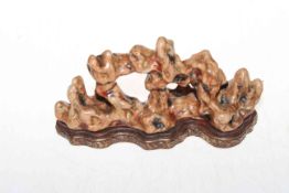 Chinese porcelain coral sculpture on shaped moulded base, gilt mark, 21cm across.