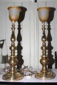 Pair of brass column table lamps with amber glass shades, 74cm high.