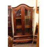 Hardwood arched top vitrine having two glazed panel doors above a drawer on ball and claw legs,