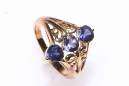 9 carat gold ring set with row of three blue stones and having pierced shoulders, size N.