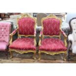 Pair gilt framed open armchairs with serpentine front seats.