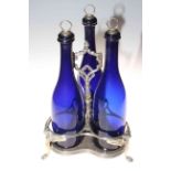 Antique silver plated and blue glass three bottle stand with winged creature legs.