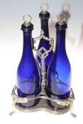 Antique silver plated and blue glass three bottle stand with winged creature legs.