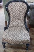 Victorian ebonised nursing chair on turned legs.