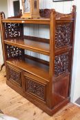 Victorian mahogany buffet having three open shelves with fretwork panelled sides above two carved