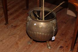 Brass coal bucket on three hoofed feet with fire place accessories.