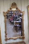 Arched top ornate gilt framed wall mirror, 152cm by 87cm overall.
