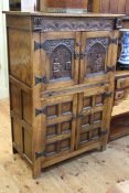 Carved oak four door drinks cabinet, 125cm high by 83cm wide by 47cm deep.