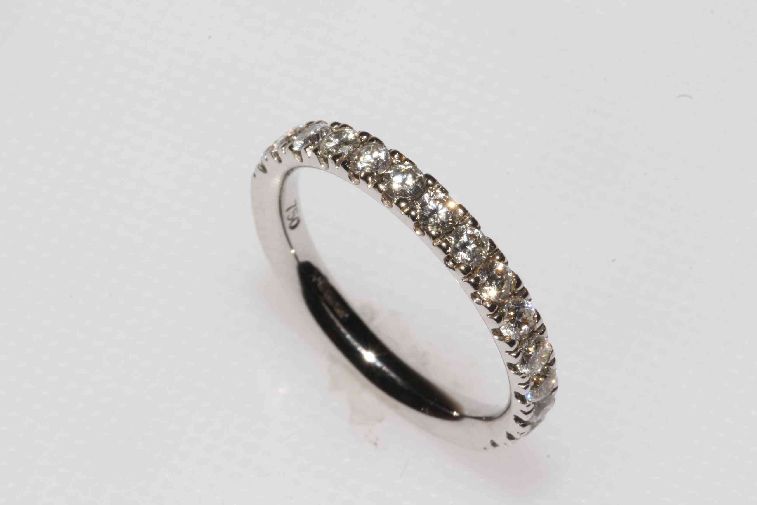 Diamond half eternity ring set in 18 carat white gold and having fifteen brilliant cut diamonds,