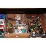 Two boxes of glass bottles, matchboxes and other smoking related items.