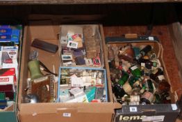 Two boxes of glass bottles, matchboxes and other smoking related items.