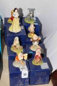 Disney Showcase by Royal Doulton, eight pieces comprising Snow White, five Dwarfs, Tramp and Lady.