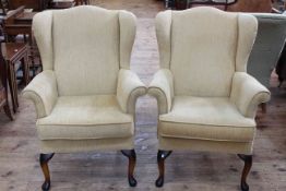 Pair Parker Knoll wing armchairs in light gold fabric.
