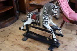 Sponge painted rocking horse on safety stand, 94cm by 97cm.