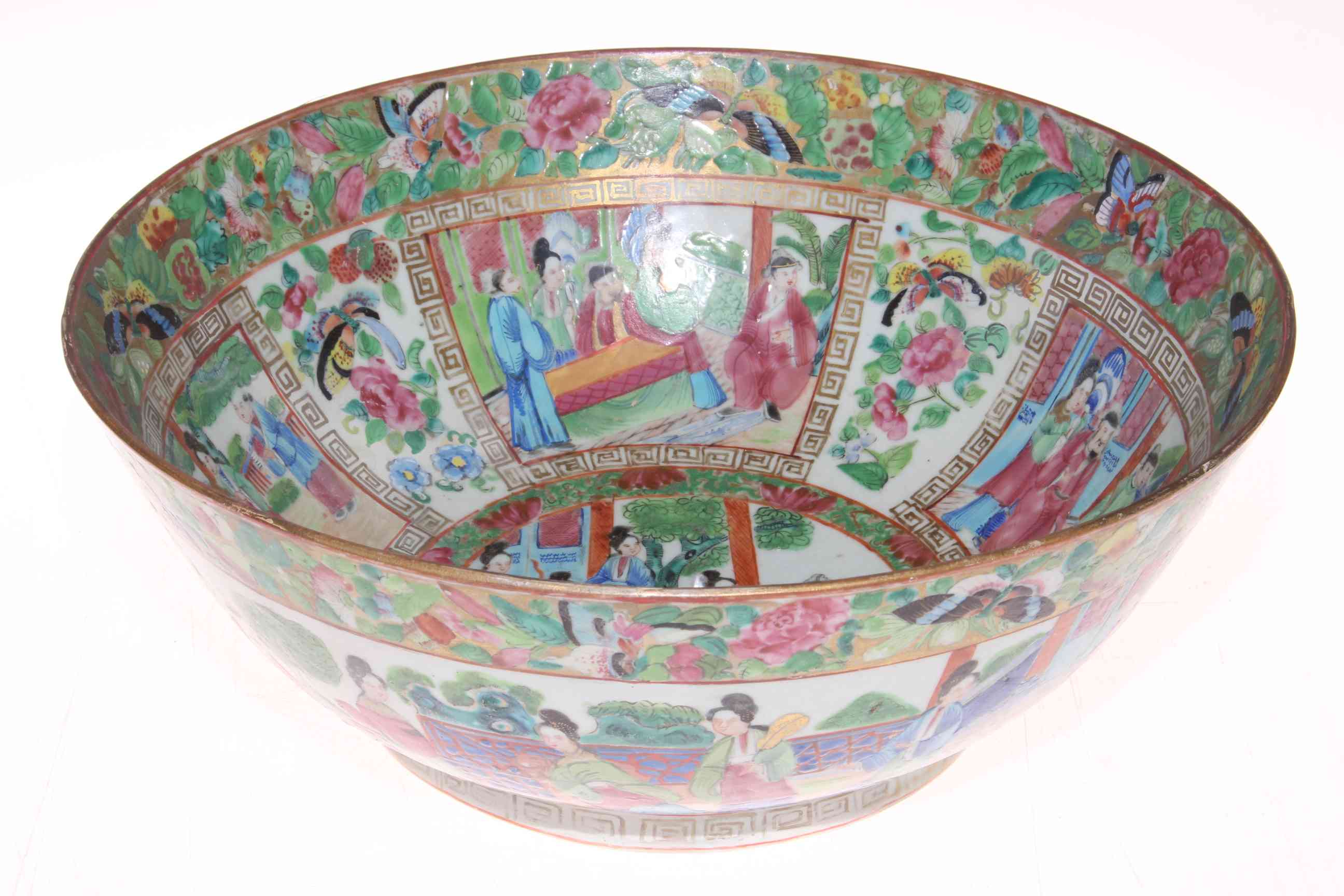 Large Chinese famille rose bowl with many panels of figures on foliate and butterfly ground,