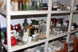 Full shelf of china and glass, clown doll, glass butter churn, collectors plates. mantel clock, etc.