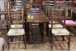 Large oak gate leg dining table, 169cm long, together with eight rush seated dining chairs,