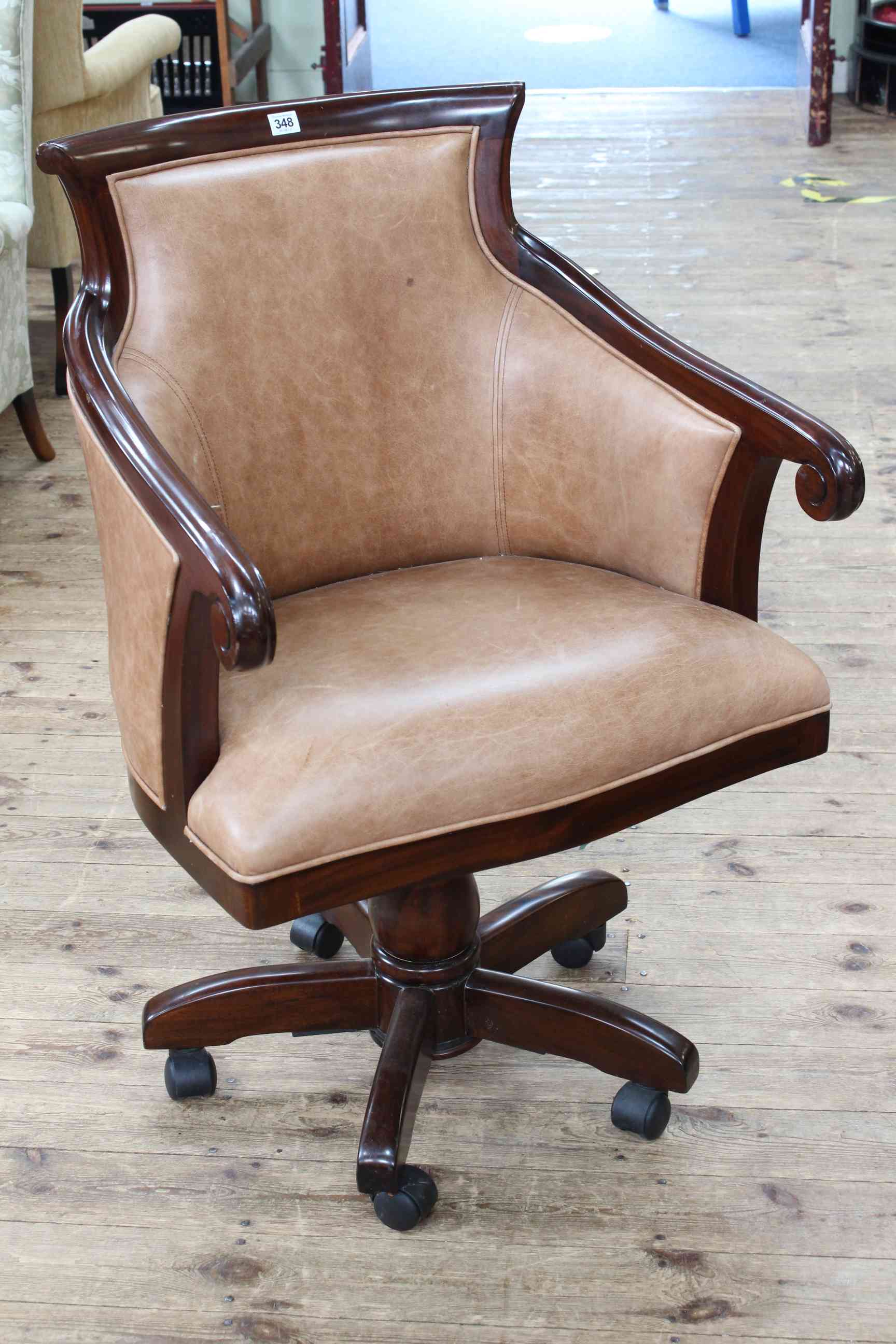 Mahogany framed and light brown leather swivel armchair.